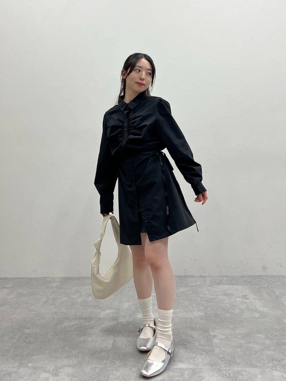 ブラック系のワンピースを着用したレディースの春コーディネートの2枚目の写真