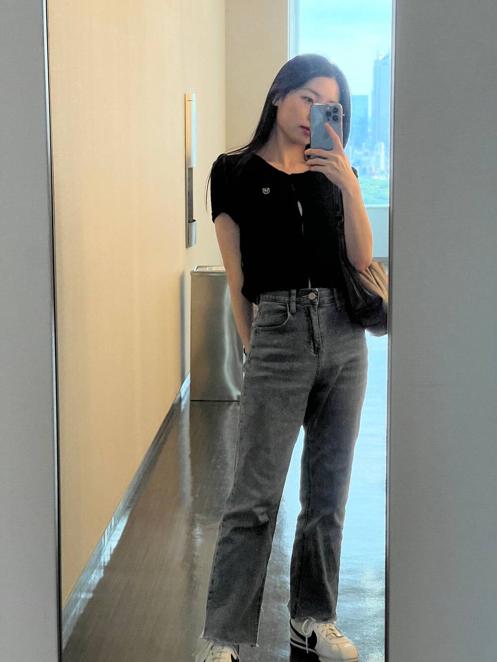 ホワイト系のスカート、ブルー系のトートバッグ、ブラック系のカーディガン/ボレロを着用したレディースの夏コーディネートの5枚目の写真