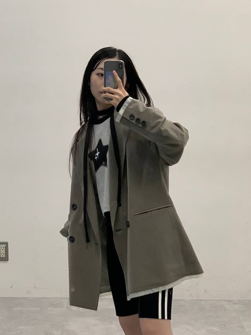 ブラック系のサンダル、グレー系のTシャツ/カットソー、ベージュ系のテーラードジャケットを着用したレディースの秋コーディネートの5枚目の写真