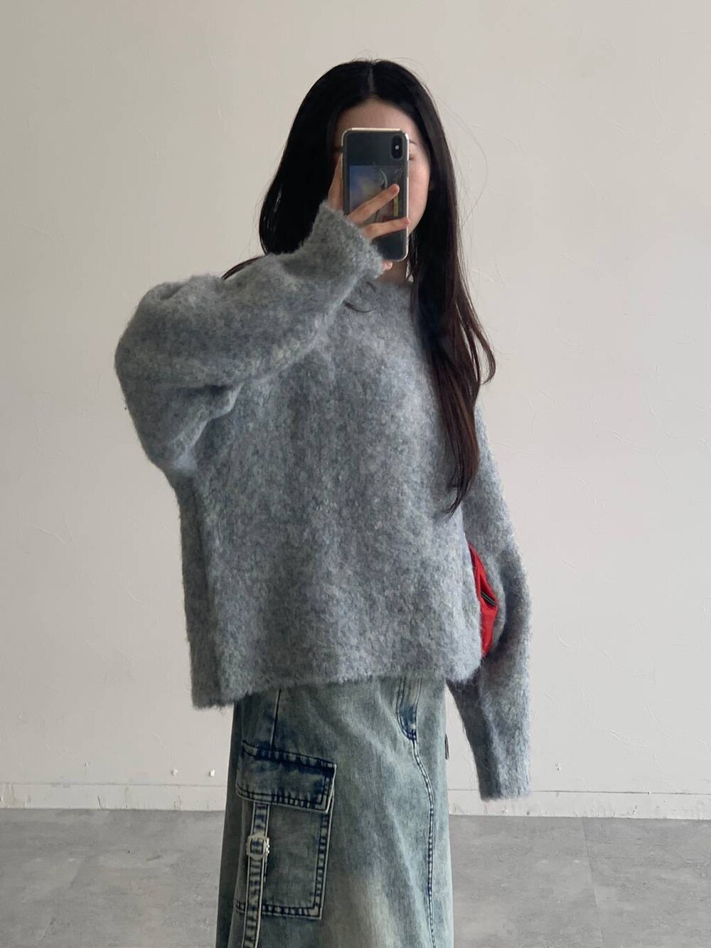 ブルー系のデニムスカート、グレー系のニット/セーターを着用したレディースの秋コーディネートの6枚目の写真