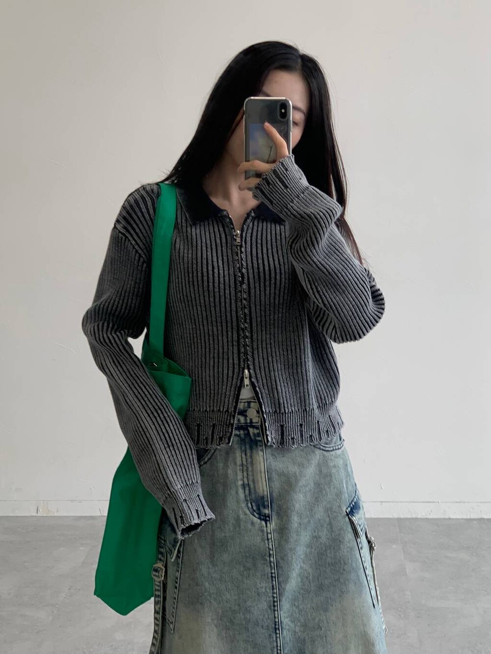 ブルー系のデニムスカート、グリーン系のトートバッグ、ブラック系のニット/セーターを着用したレディースの秋コーディネートの5枚目の写真