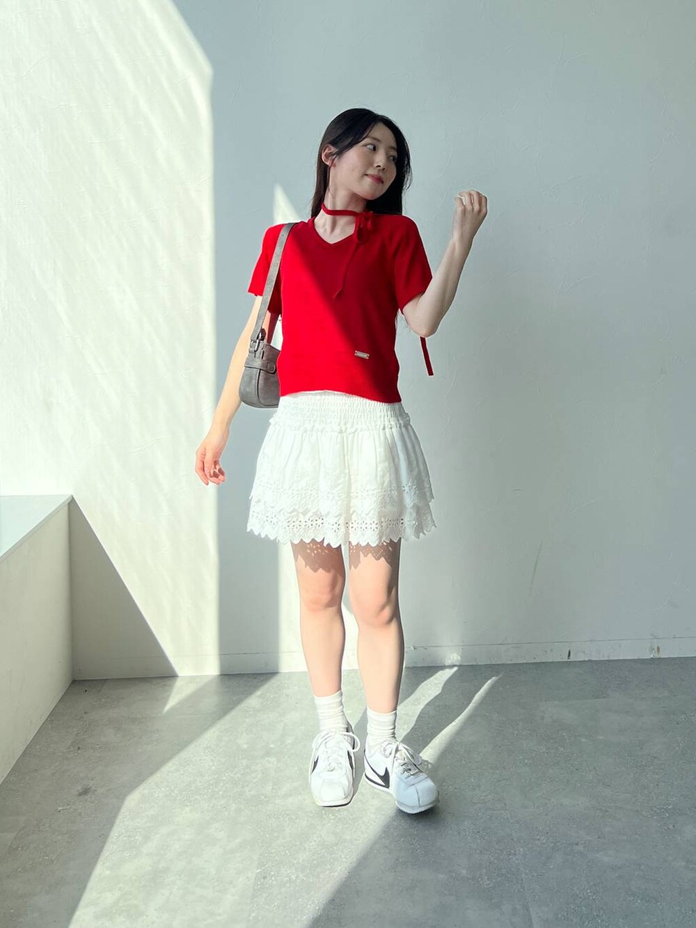 ホワイト系のスカート、ブラック系のトートバッグ、レッド系のニット/セーターを着用したレディースの夏コーディネートの8枚目の写真