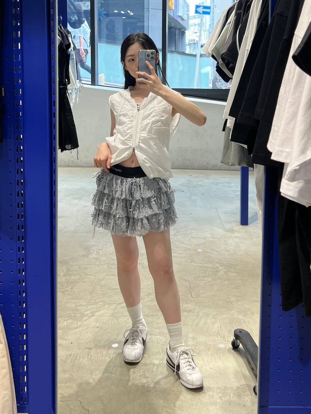 ホワイト系のスカート、ホワイト系のベストを着用したレディースの夏コーディネートの2枚目の写真