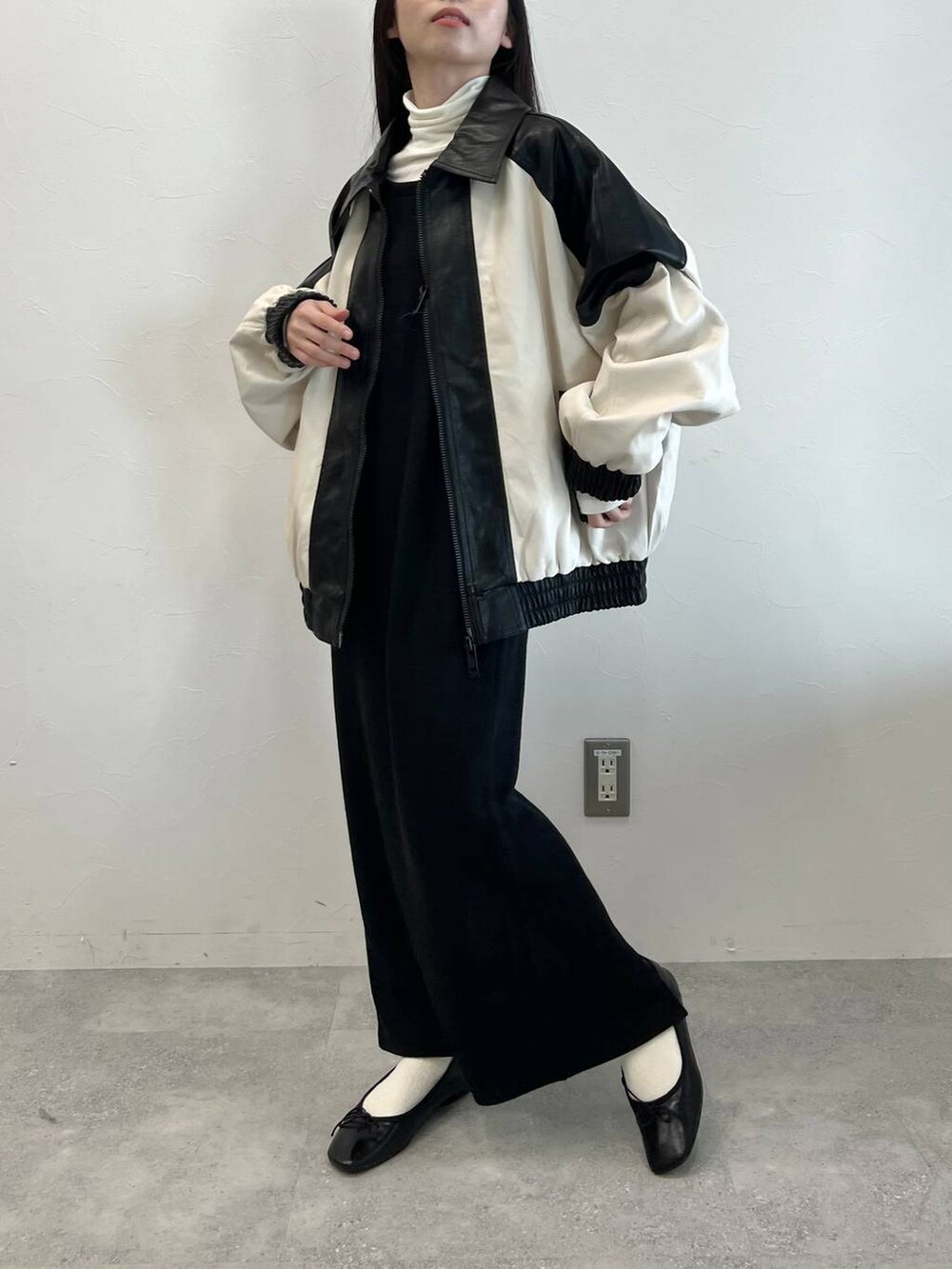 ブラック系のワンピース、ブラック系のバレエシューズ、ベージュ系のTシャツ/カットソーを着用したレディースの冬コーディネートの3枚目の写真