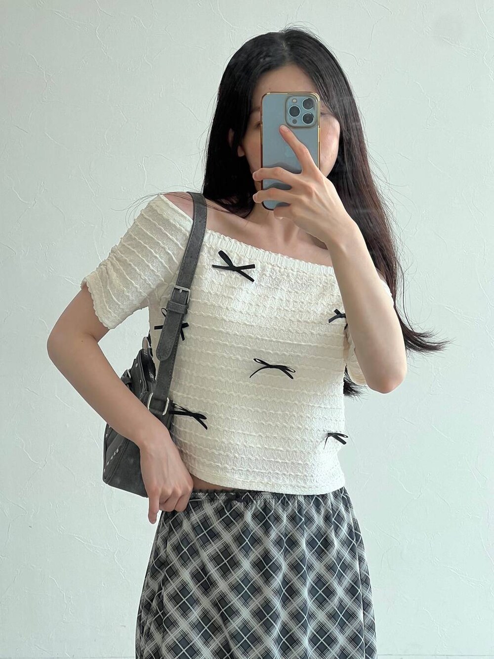 ホワイト系のTシャツ/カットソー、グレー系のスカート、ブラック系のトートバッグを着用したレディースの夏コーディネートの6枚目の写真