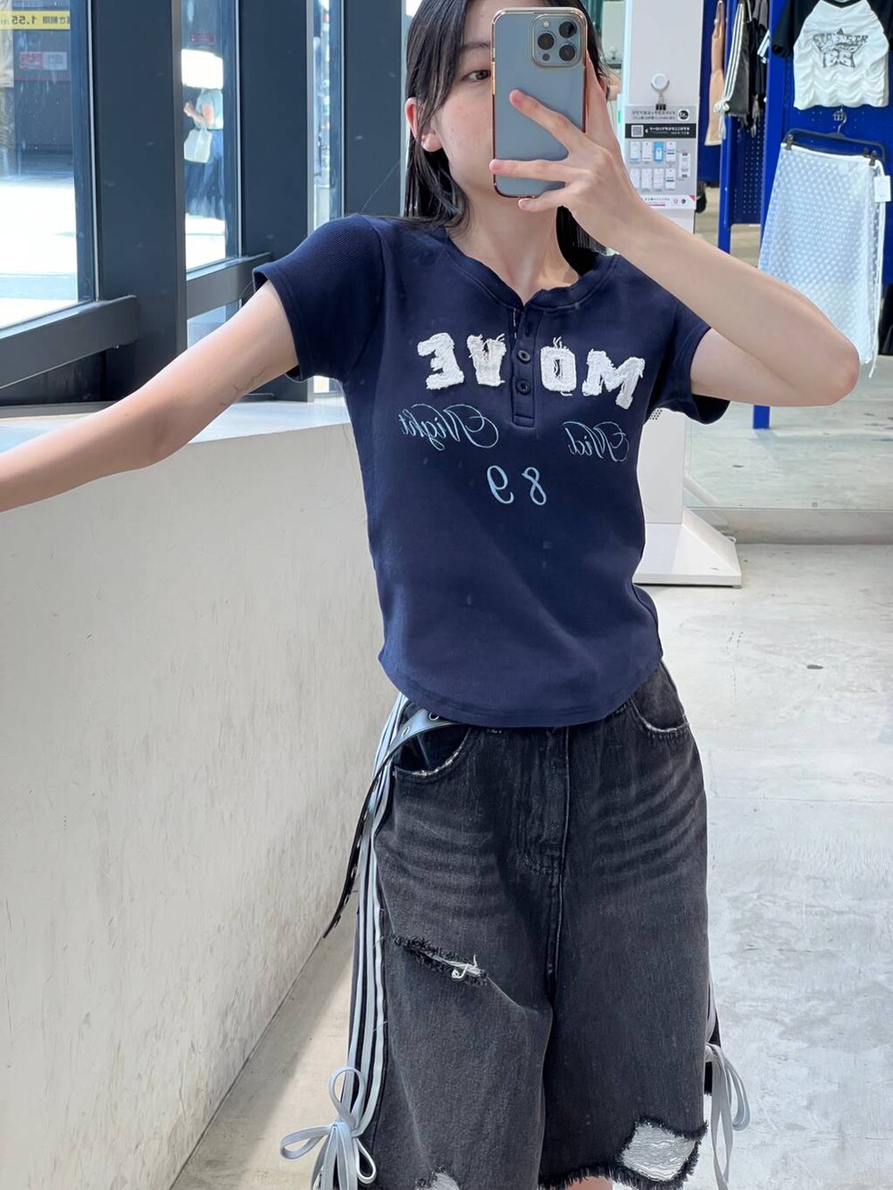 ブラック系のデニムパンツ、ブルー系のTシャツ/カットソー、ブラック系のベルトを着用したレディースの夏コーディネートの3枚目の写真