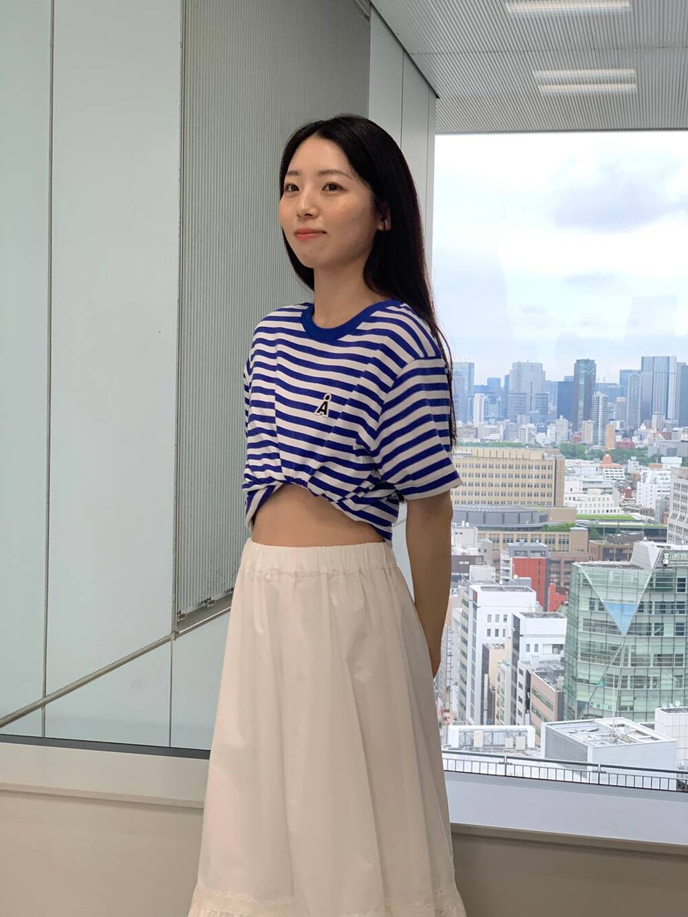 ホワイト系のスカート、ブルー系のTシャツ/カットソーを着用したレディースの夏コーディネートの5枚目の写真