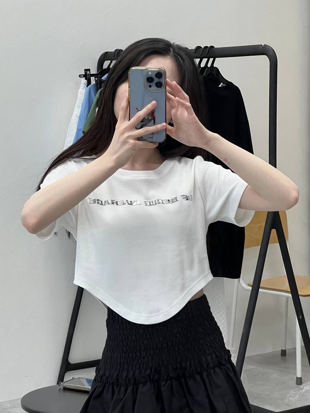 ブラック系のスカート、ホワイト系のTシャツ/カットソーを着用したレディースの春コーディネートの6枚目の写真