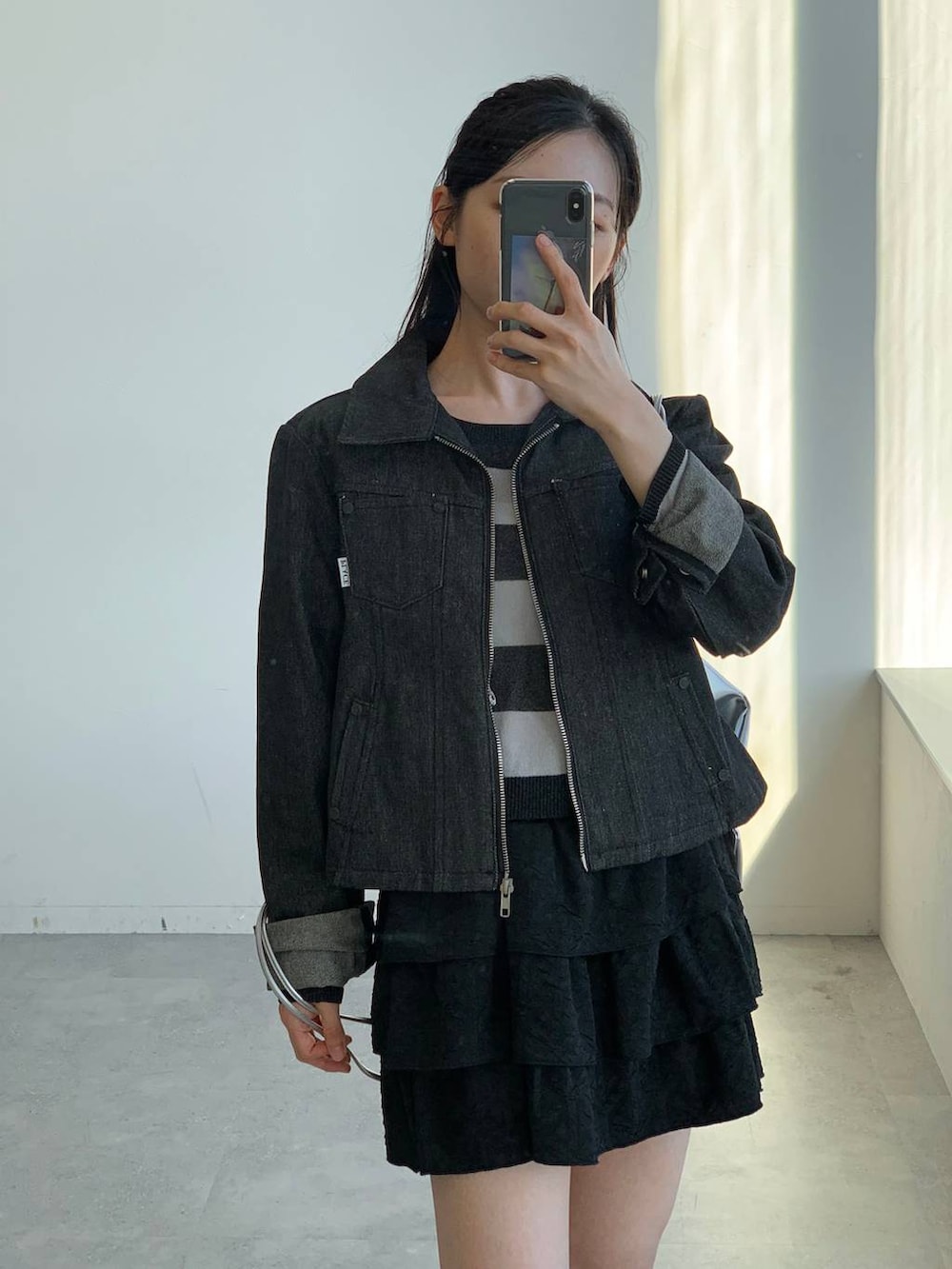 ブラック系のショルダーバッグ、ブラック系のスカート、ブラック系のニット/セーターを着用したレディースの秋コーディネートの6枚目の写真