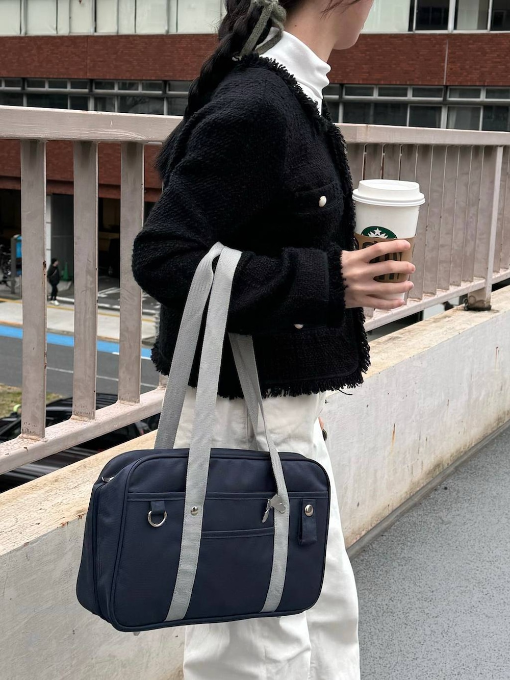 ブルー系のトートバッグ、ブラック系のジャケット/アウター、ホワイト系のTシャツ/カットソーを着用したレディースの冬コーディネートの2枚目の写真