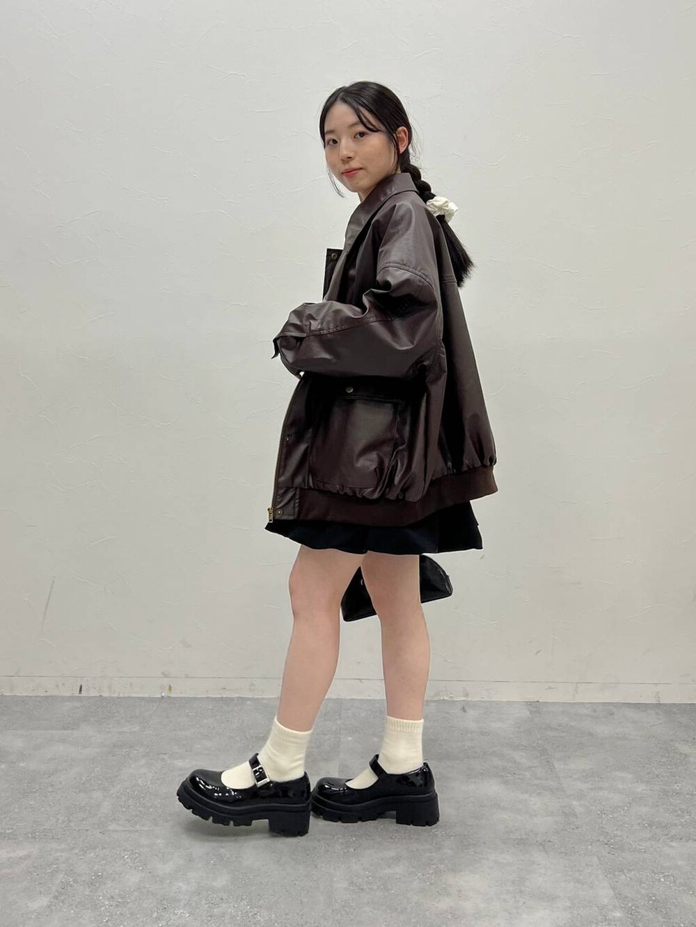 ブラウン系のブルゾン、グレー系のスウェット、ブラック系のハンドバッグを着用したレディースの冬コーディネートの2枚目の写真