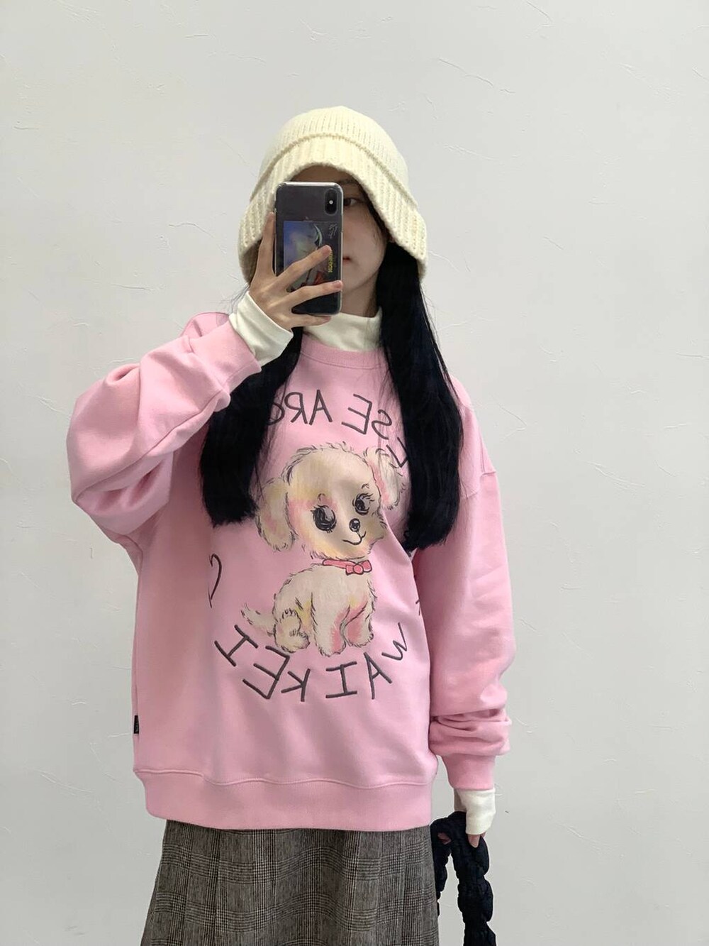 ブラック系のショルダーバッグ、ブラウン系のスカート、ピンク系のスウェットを着用したレディースの冬コーディネートの7枚目の写真