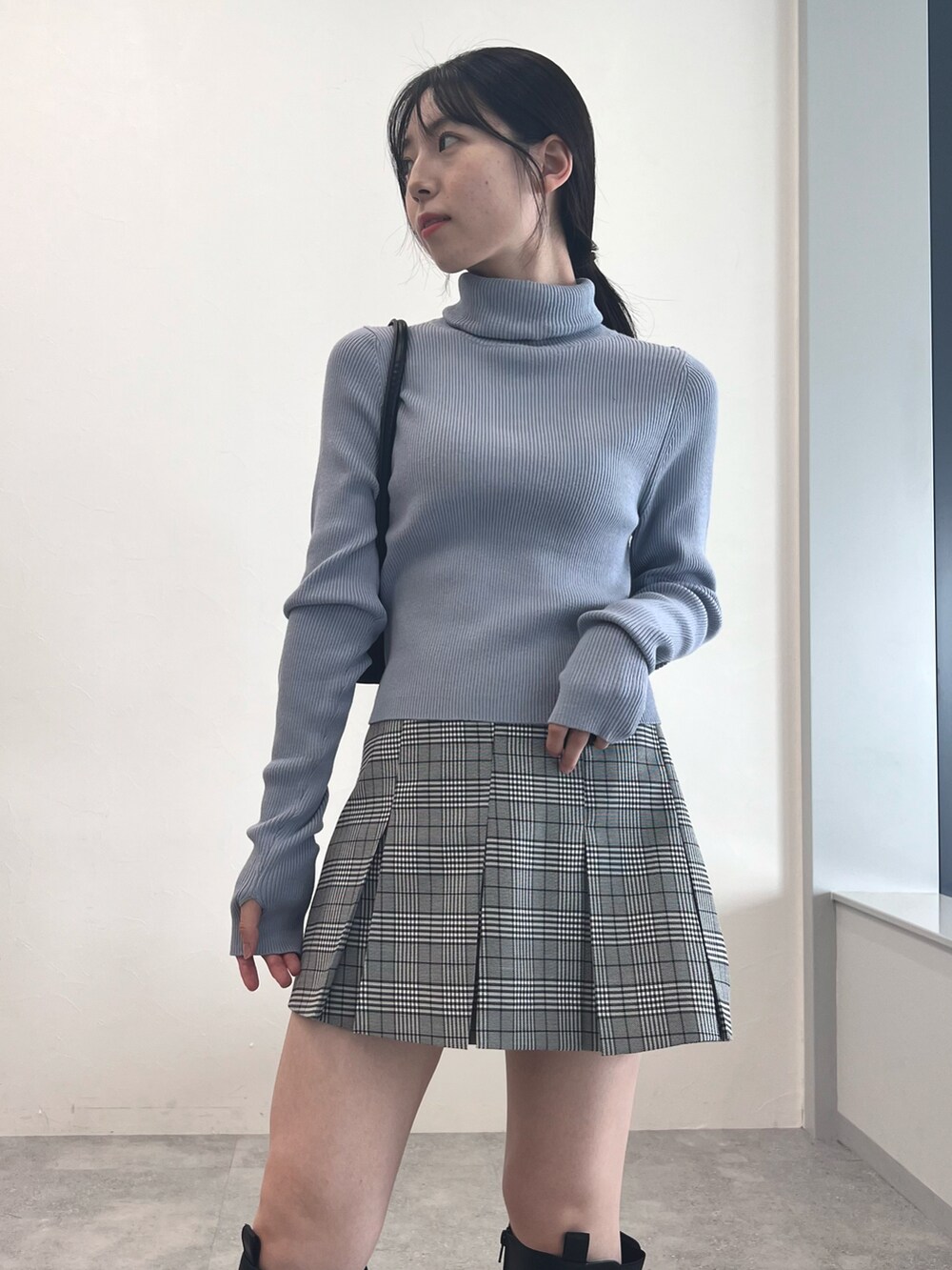 ブラック系のブーツ、グレー系のスカート、ブルー系のニット/セーターを着用したレディースの冬コーディネートの4枚目の写真