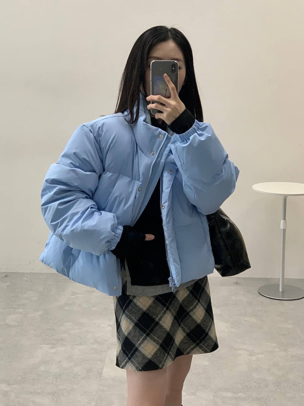 ブラック系のスカート、ブラック系のハンドバッグ、ブラック系のTシャツ/カットソーを着用したレディースの冬コーディネートの5枚目の写真