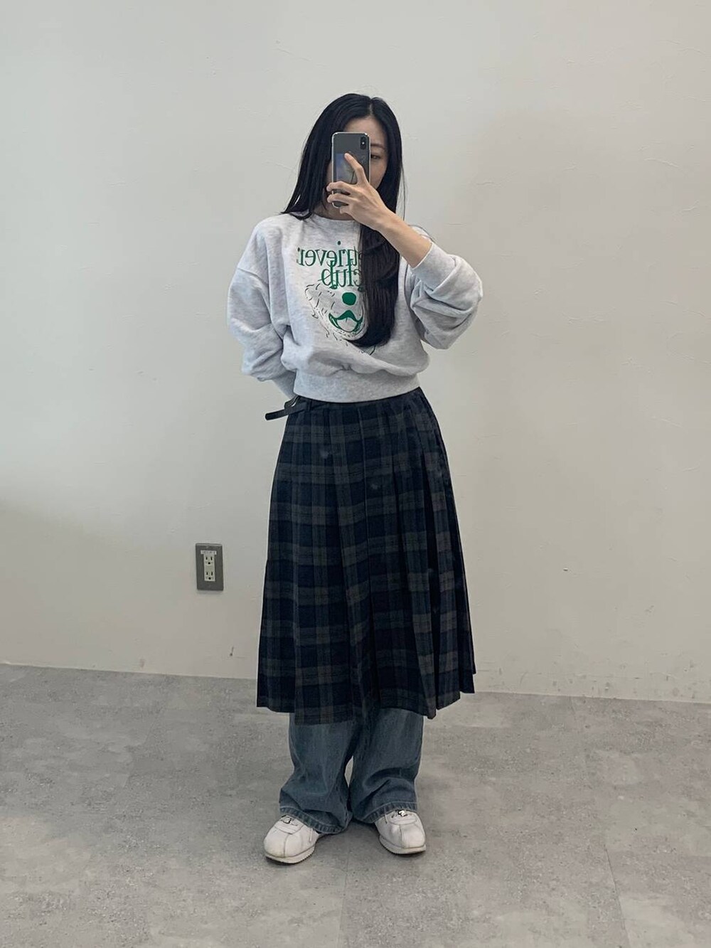 グレー系のスカート、グリーン系のスウェットを着用したレディースの秋コーディネートの2枚目の写真