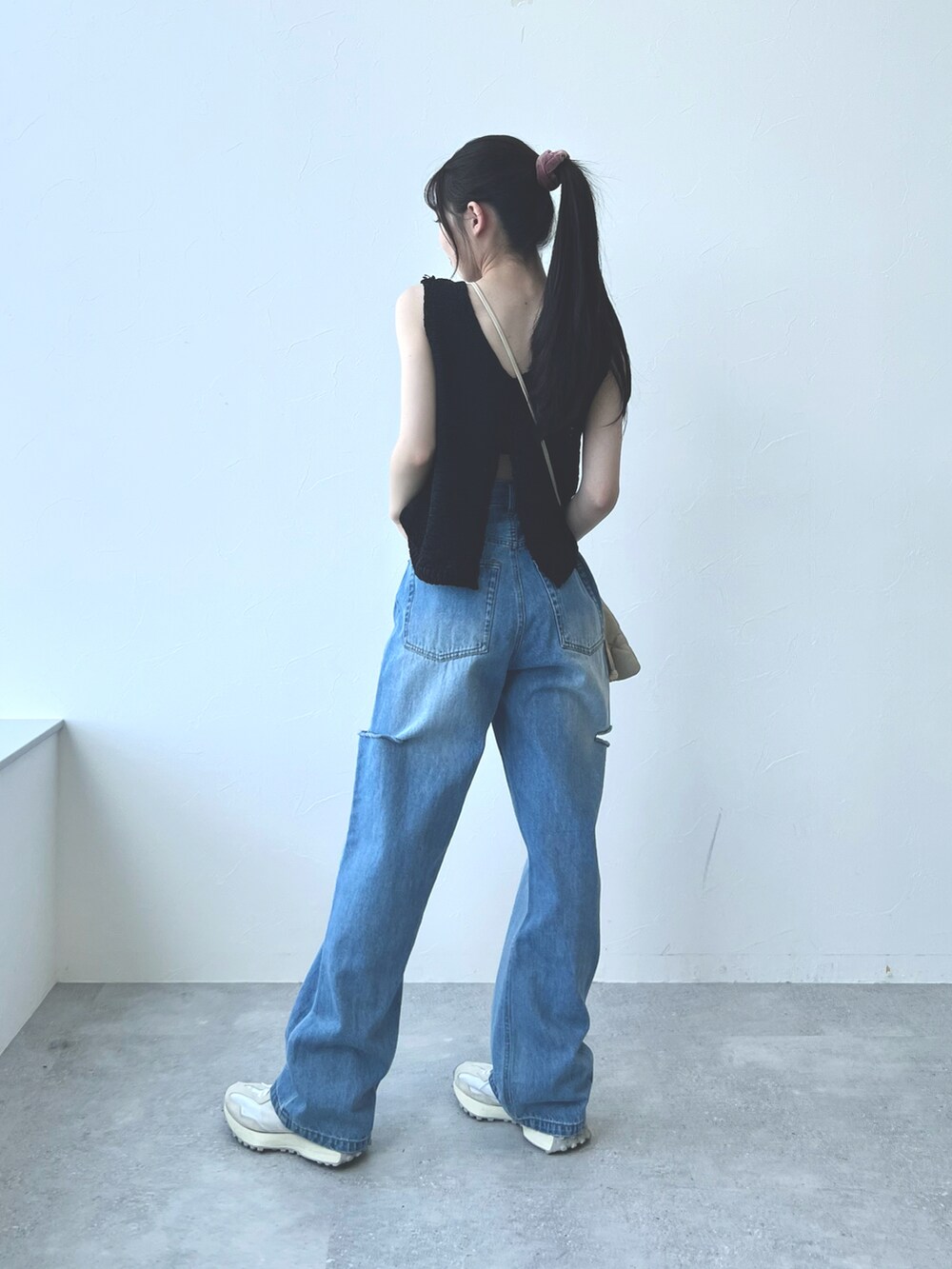 ホワイト系のスニーカー、ブルー系のデニムパンツ、ベージュ系のショルダーバッグを着用したレディースの夏コーディネートの2枚目の写真