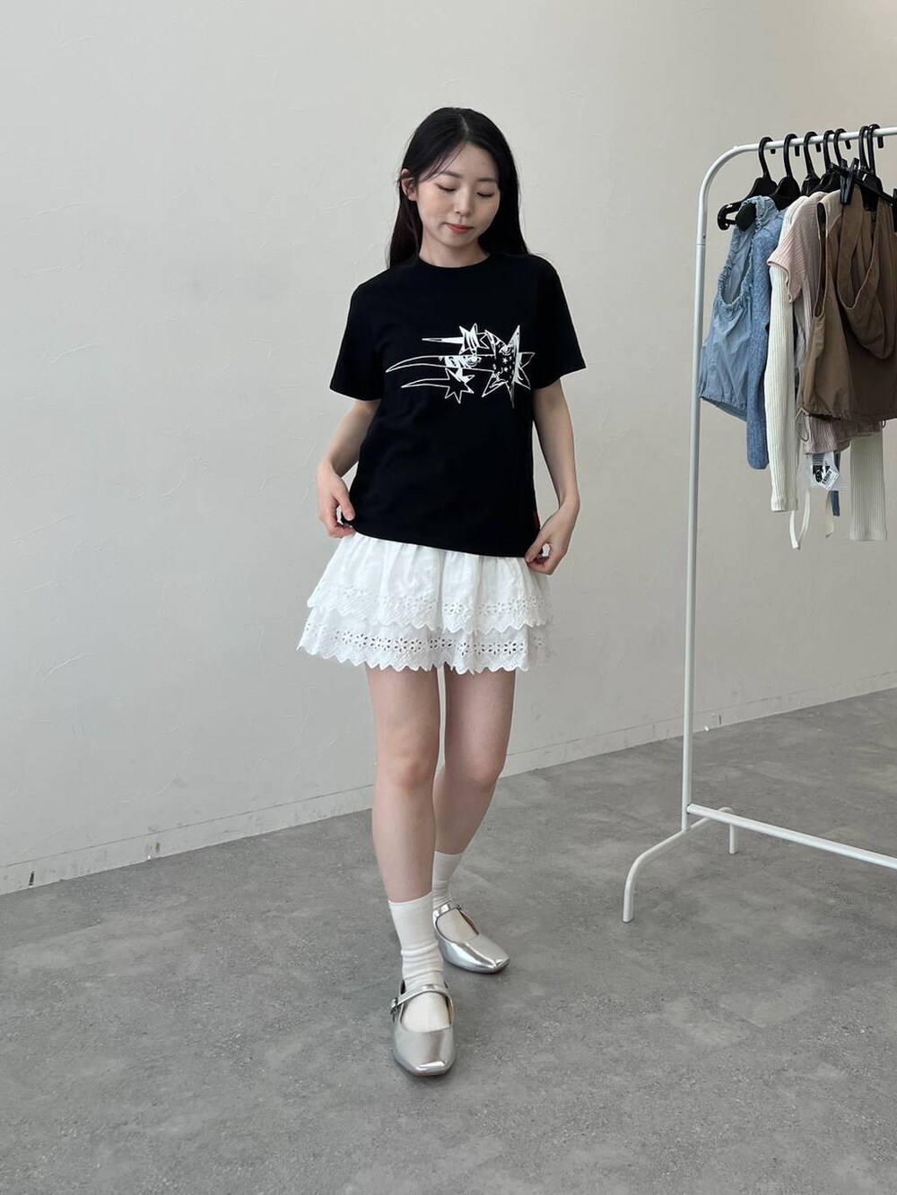 ホワイト系のスカート、ブラック系のTシャツ/カットソーを着用したレディースの夏コーディネートの4枚目の写真