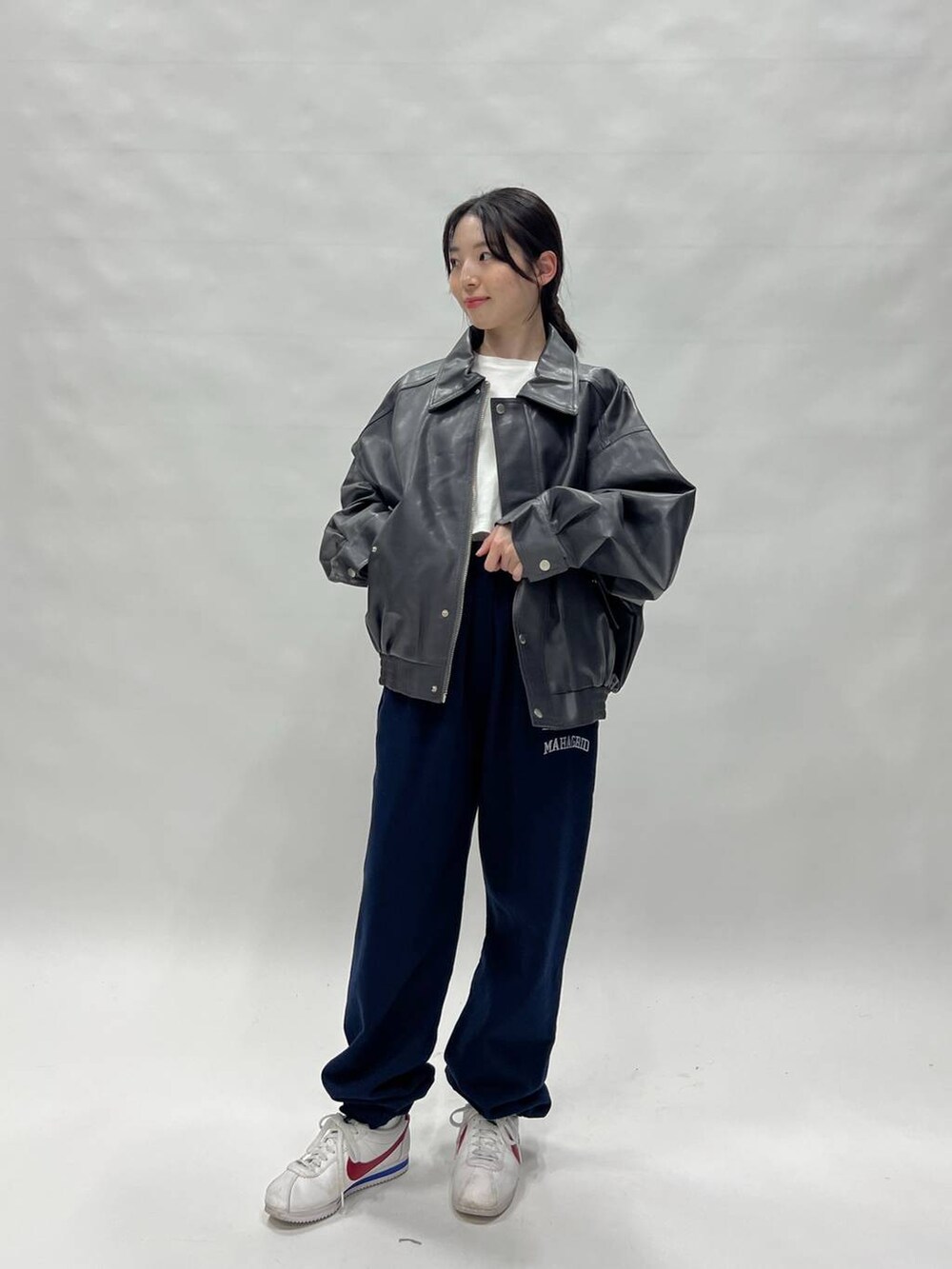 グレー系のブルゾン、ホワイト系のスニーカー、ブルー系のスウェットパンツを着用したレディースの冬コーディネートの6枚目の写真