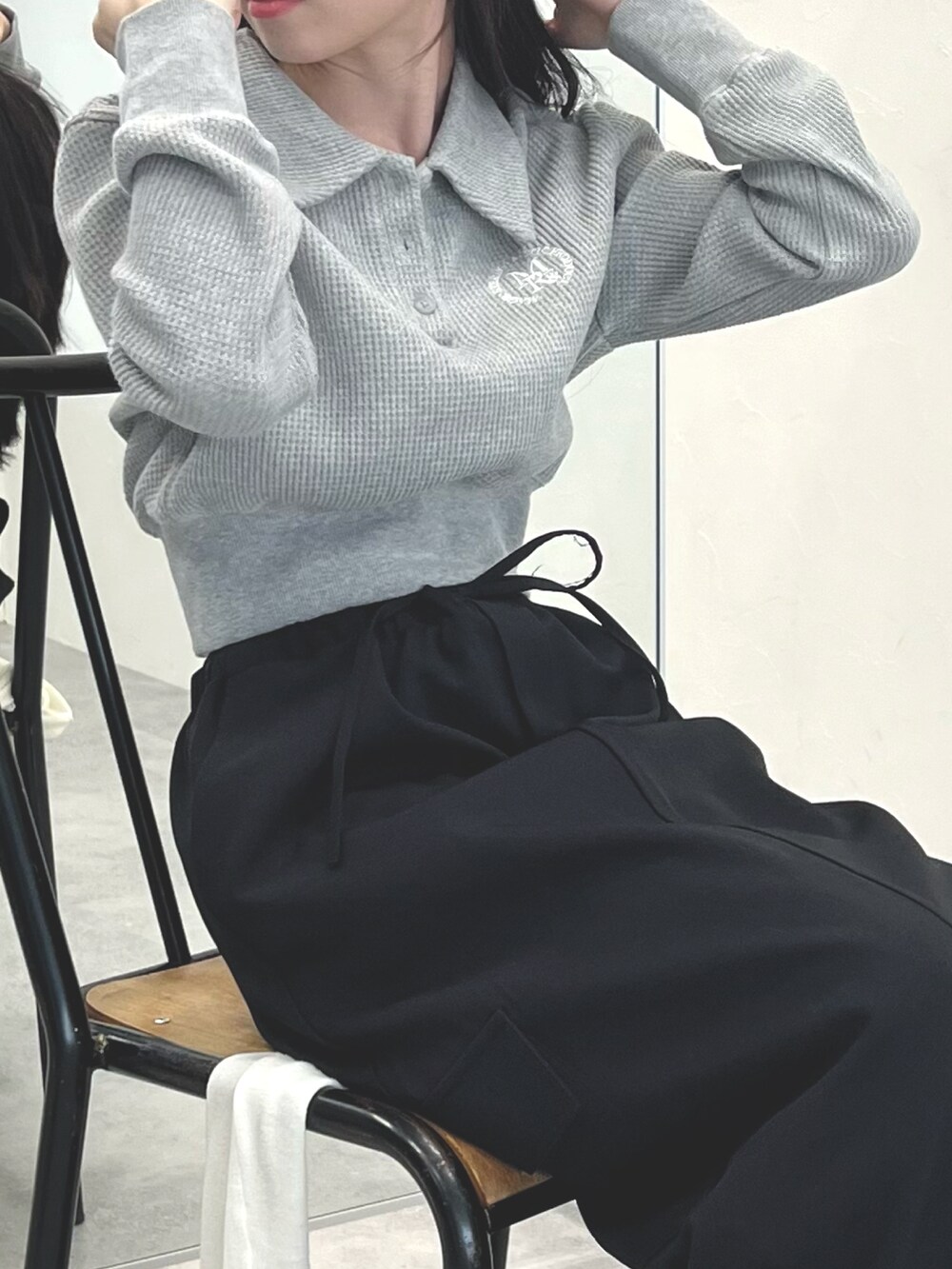 ブラック系のスカート、ブラック系のブーツ、グレー系のTシャツ/カットソーを着用したレディースの冬コーディネートの4枚目の写真