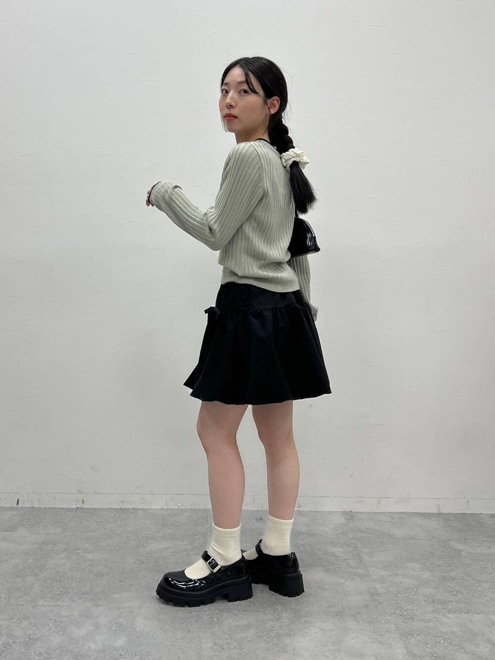 グレー系のTシャツ/カットソー、ブラック系のハンドバッグを着用したレディースの冬コーディネートの5枚目の写真