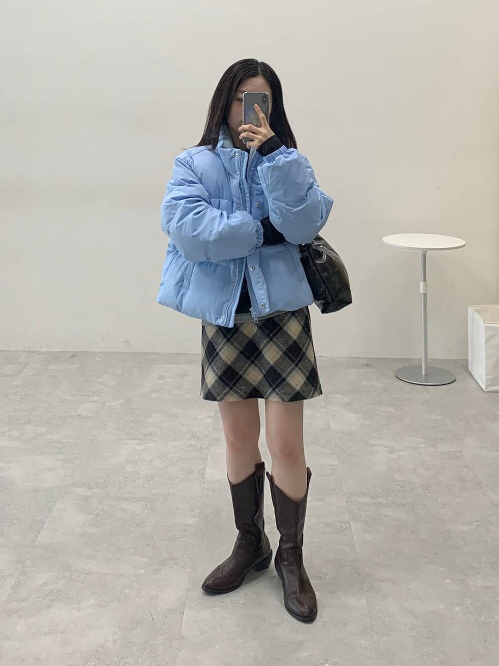 ブラック系のスカート、ブラック系のハンドバッグ、ブラック系のTシャツ/カットソーを着用したレディースの冬コーディネートの2枚目の写真