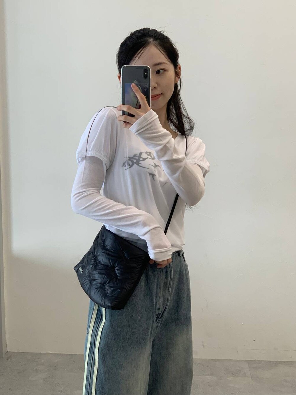 その他のデニムパンツ、ホワイト系のTシャツ/カットソー、ブラック系のショルダーバッグを着用したレディースの秋コーディネートの4枚目の写真