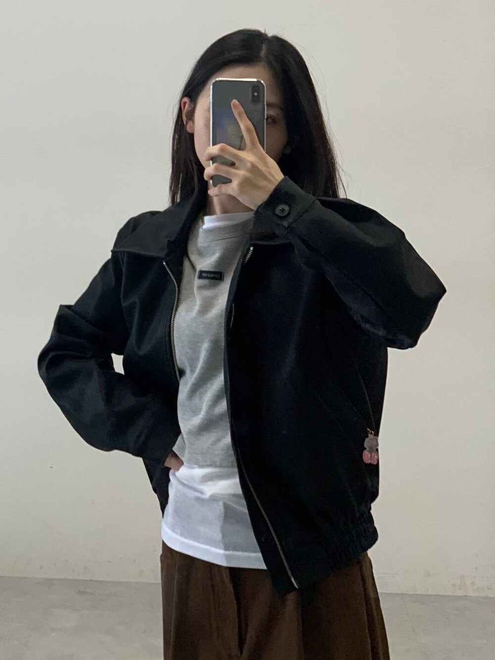 ホワイト系のTシャツ/カットソー、ブラック系のライダースジャケット、ブラウン系のその他パンツを着用したレディースの秋コーディネートの4枚目の写真