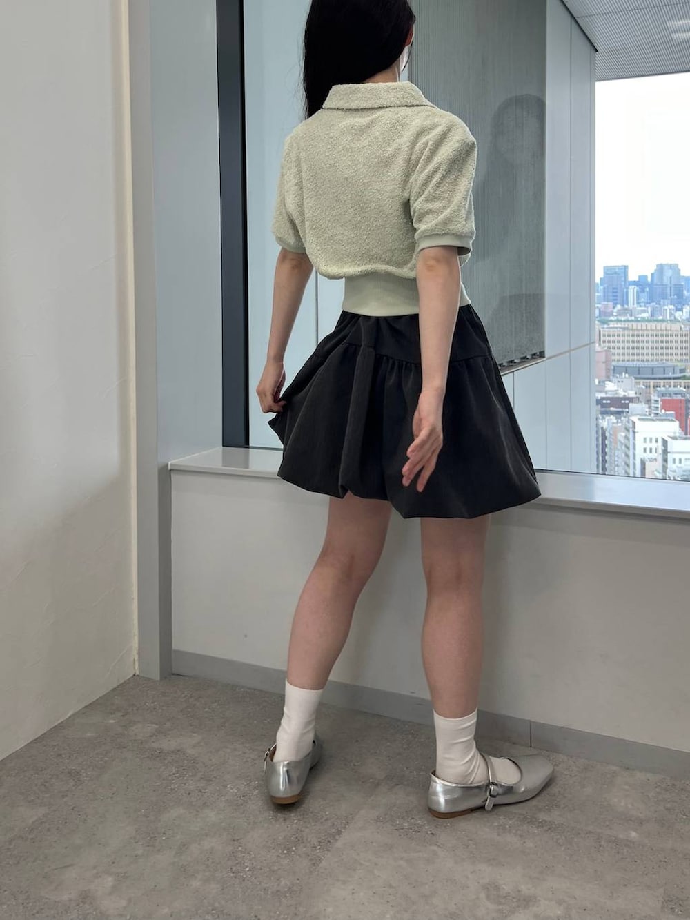 グレー系のスカート、グリーン系のTシャツ/カットソーを着用したレディースの夏コーディネートの3枚目の写真