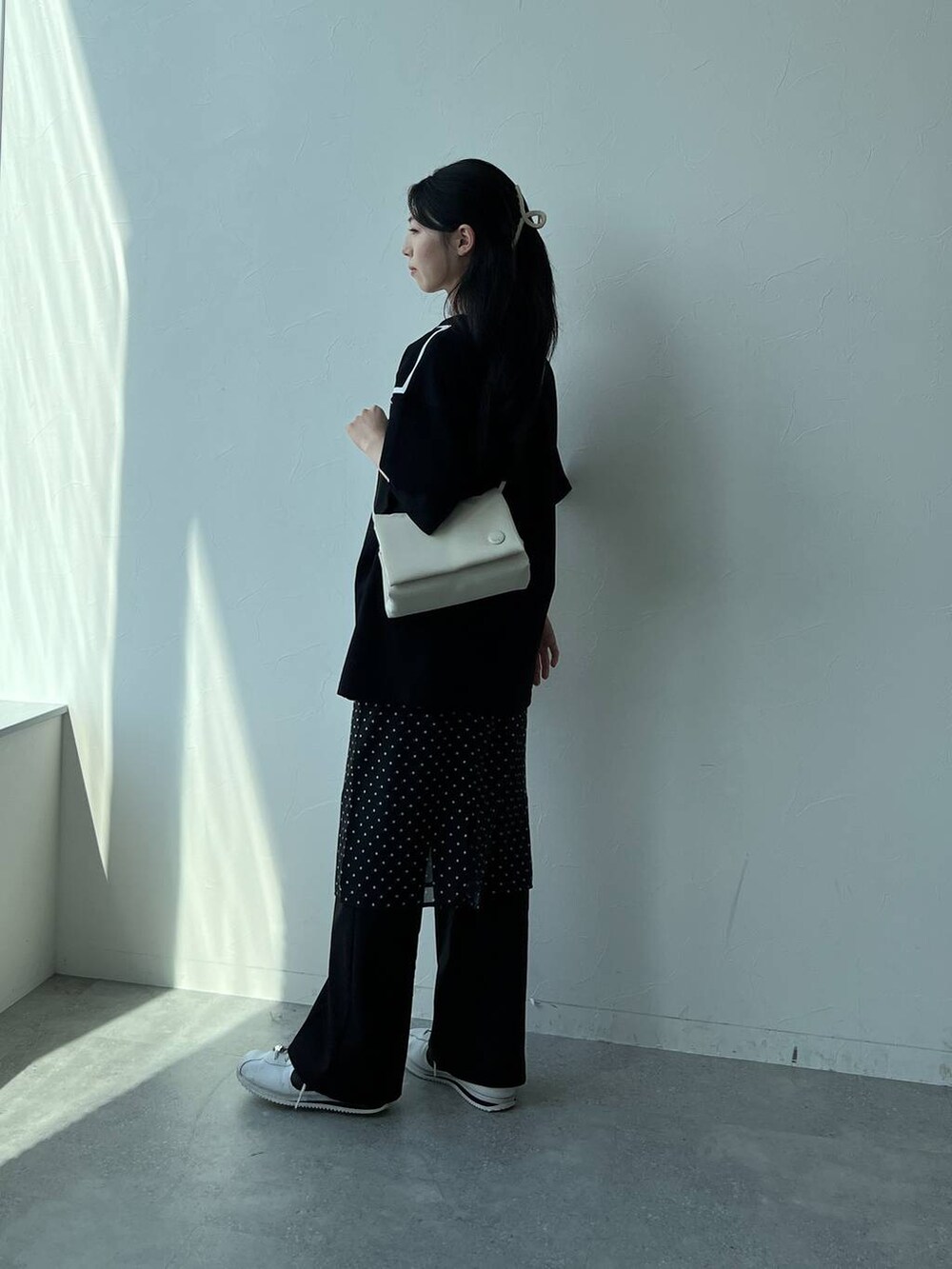 ホワイト系のハンドバッグ、ブラック系のスカートを着用したレディースの夏コーディネートの6枚目の写真