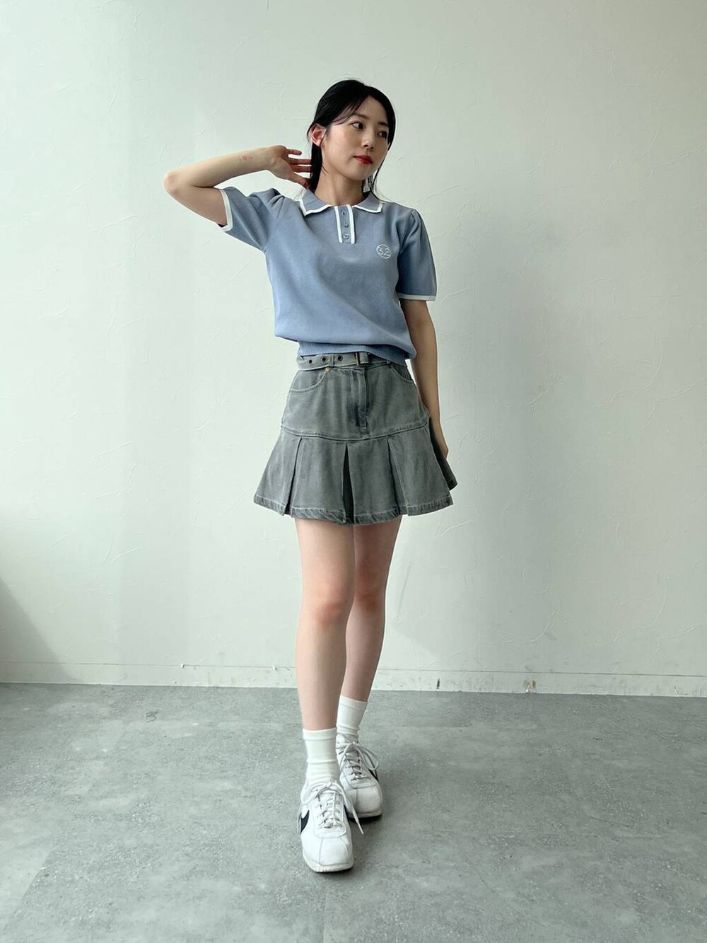 ブルー系のニット/セーター、グレー系のデニムスカートを着用したレディースの夏コーディネートの7枚目の写真