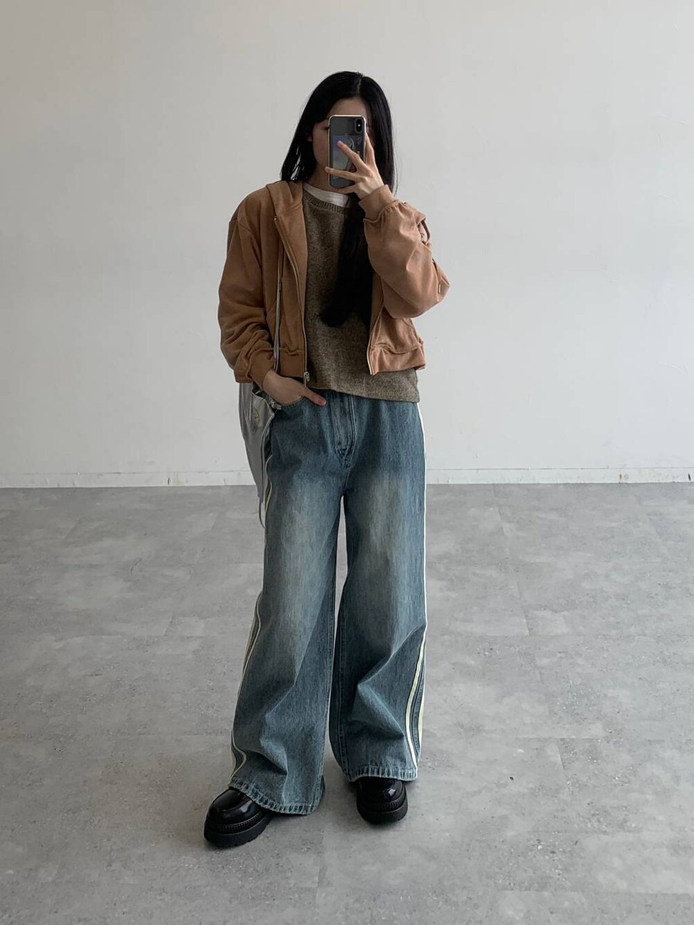 ブラウン系のパーカー、その他のデニムパンツ、グレー系のバックパック/リュックを着用したレディースの秋コーディネートの4枚目の写真