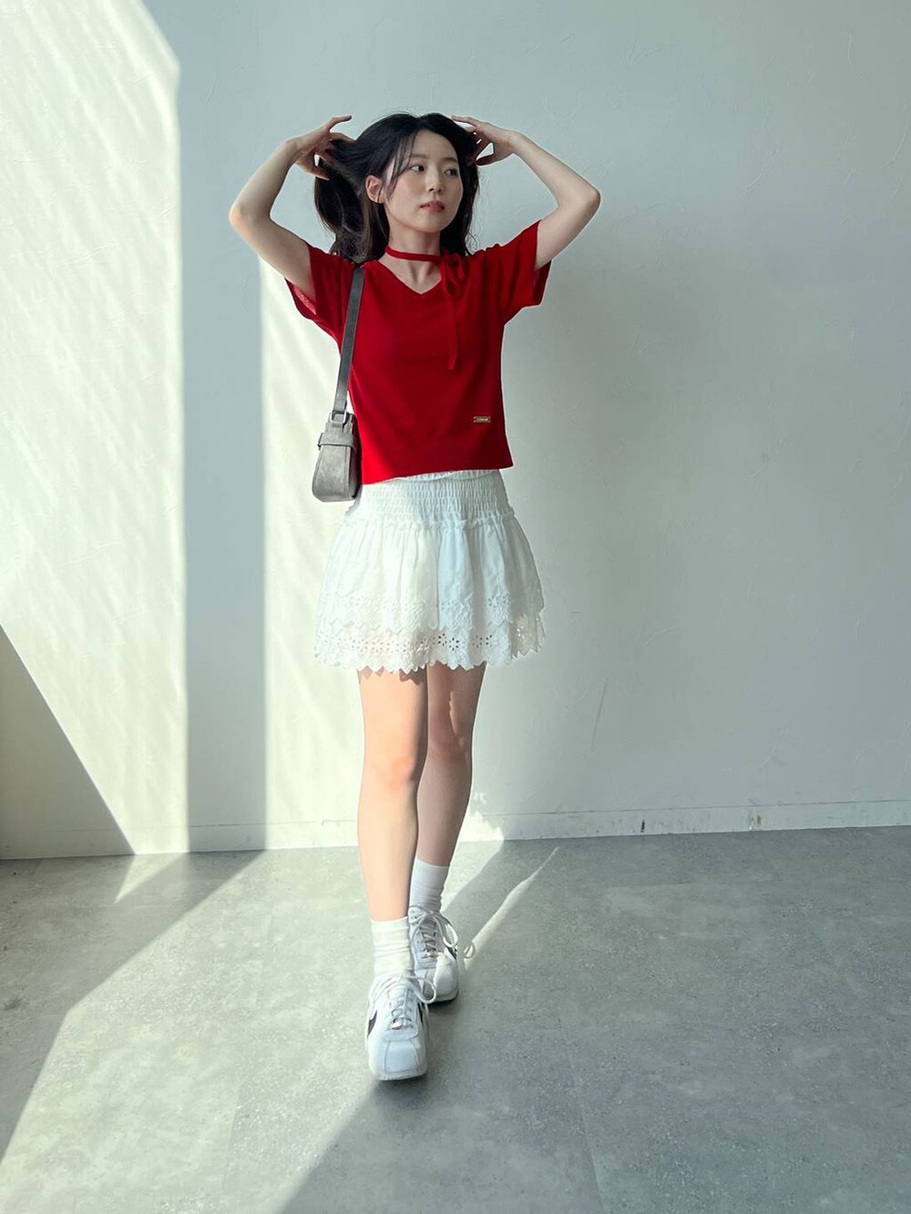 ホワイト系のスカート、ブラック系のトートバッグ、レッド系のニット/セーターを着用したレディースの夏コーディネートの6枚目の写真