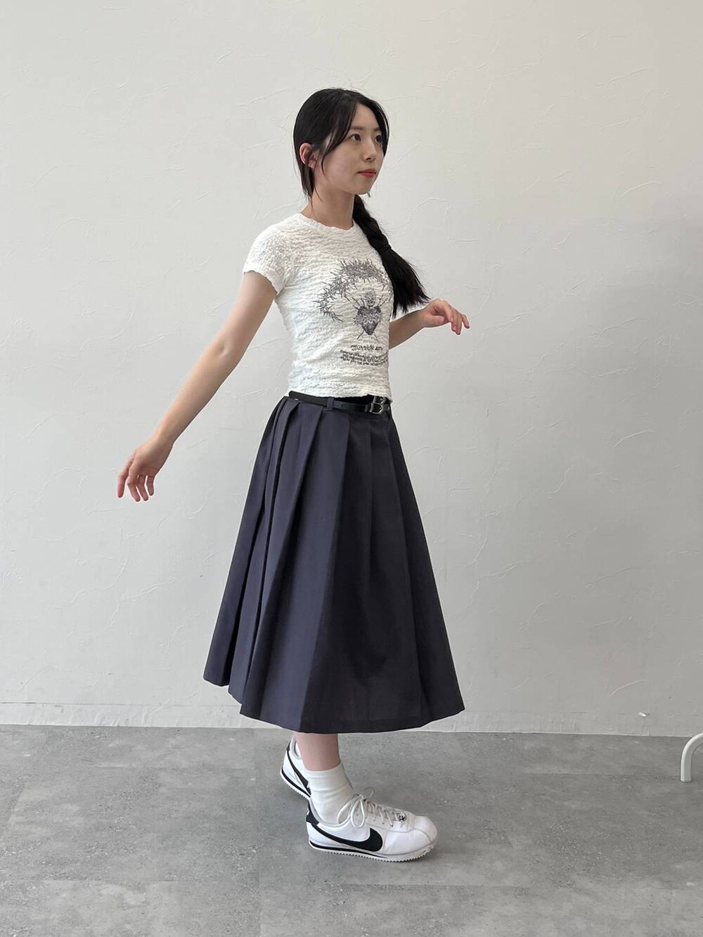 グレー系のスカート、ホワイト系のTシャツ/カットソーを着用したレディースの夏コーディネートの5枚目の写真