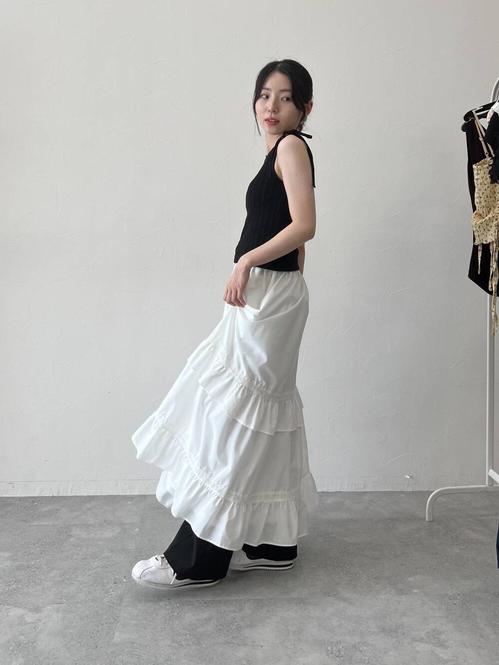 ホワイト系のスカート、ブラック系のキャミソールを着用したレディースの夏コーディネートの6枚目の写真