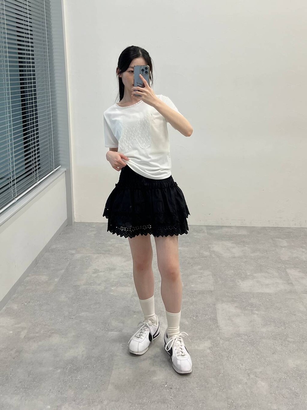 ブラック系のスカート、ホワイト系のTシャツ/カットソーを着用したレディースの夏コーディネートの2枚目の写真