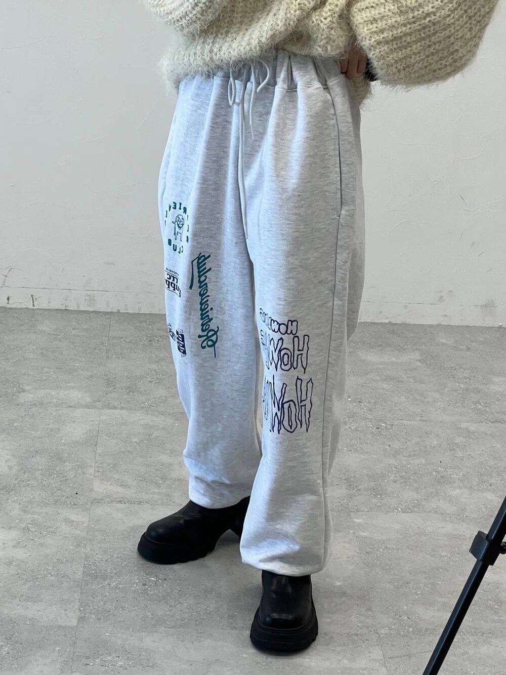 ブラック系のブーツ、ブラック系のショルダーバッグ、ベージュ系のニット/セーターを着用したレディースの冬コーディネートの6枚目の写真