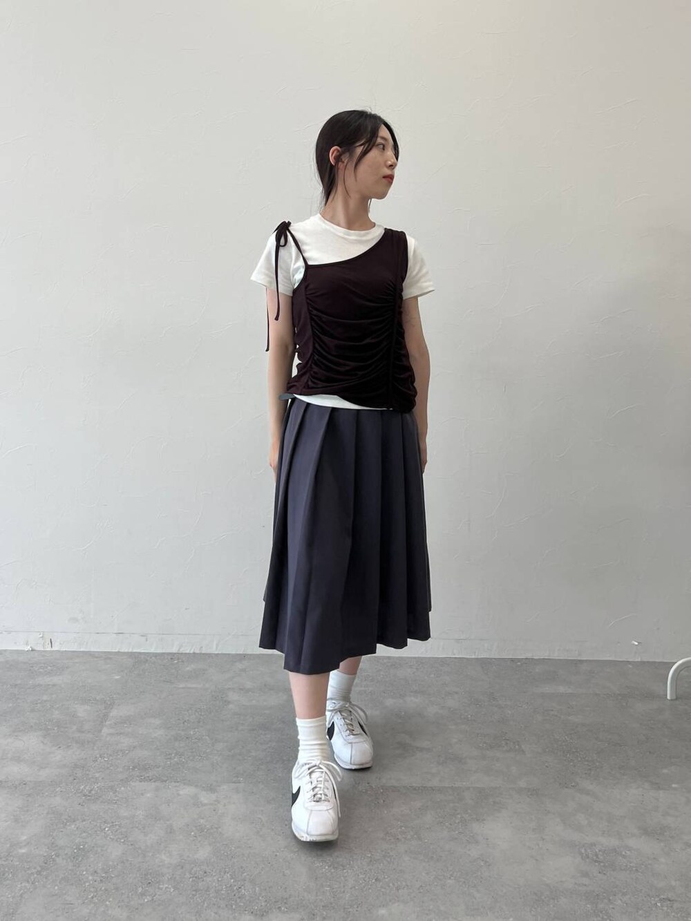 グレー系のスカート、ブラウン系のキャミソールを着用したレディースの夏コーディネートの2枚目の写真