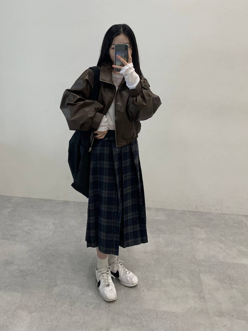 ブラック系のショルダーバッグ、ブラウン系のブルゾン、グレー系のスカートを着用したレディースの秋コーディネートの4枚目の写真