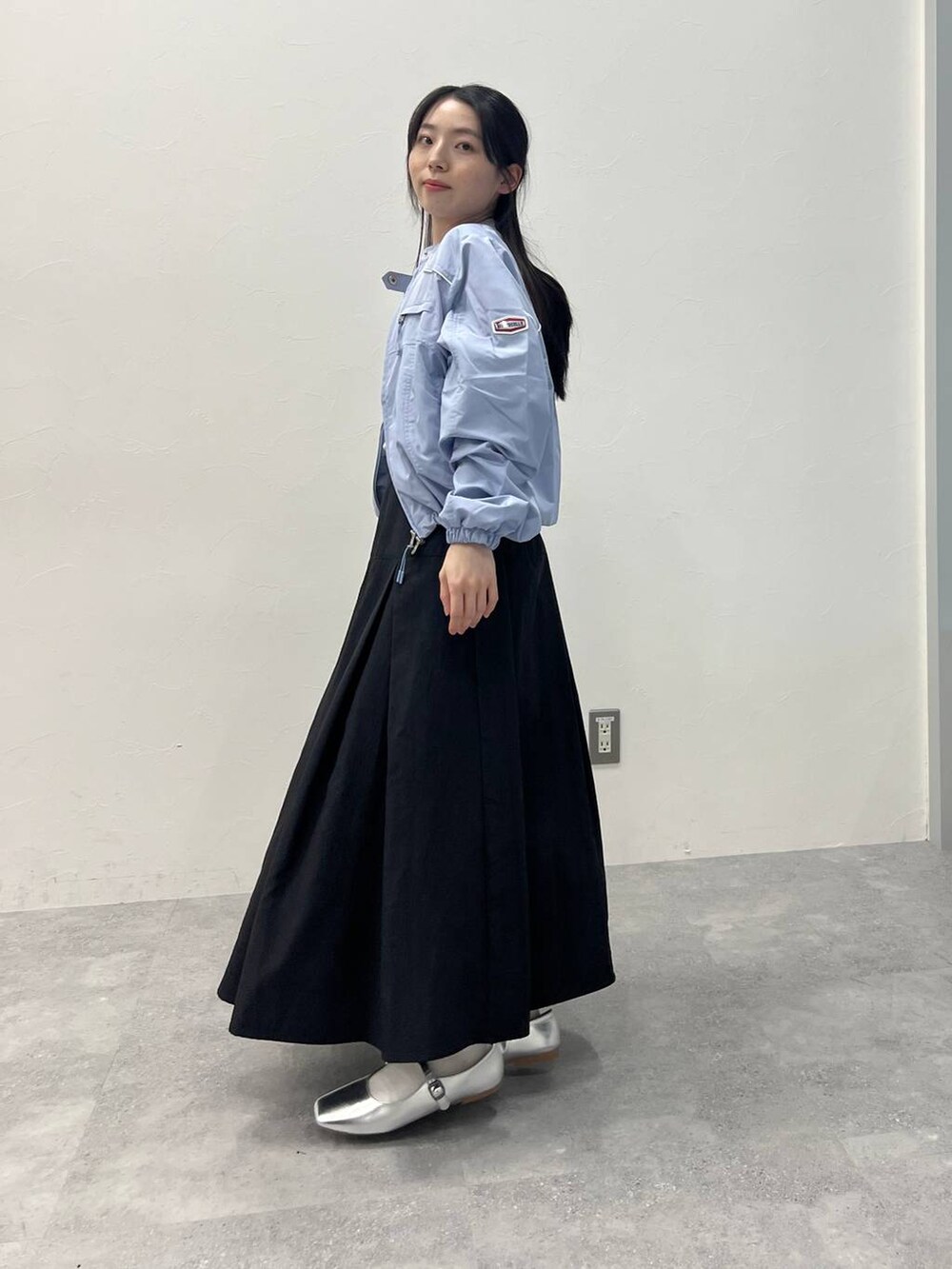 ブラック系のスカートを着用したレディースの春コーディネートの4枚目の写真