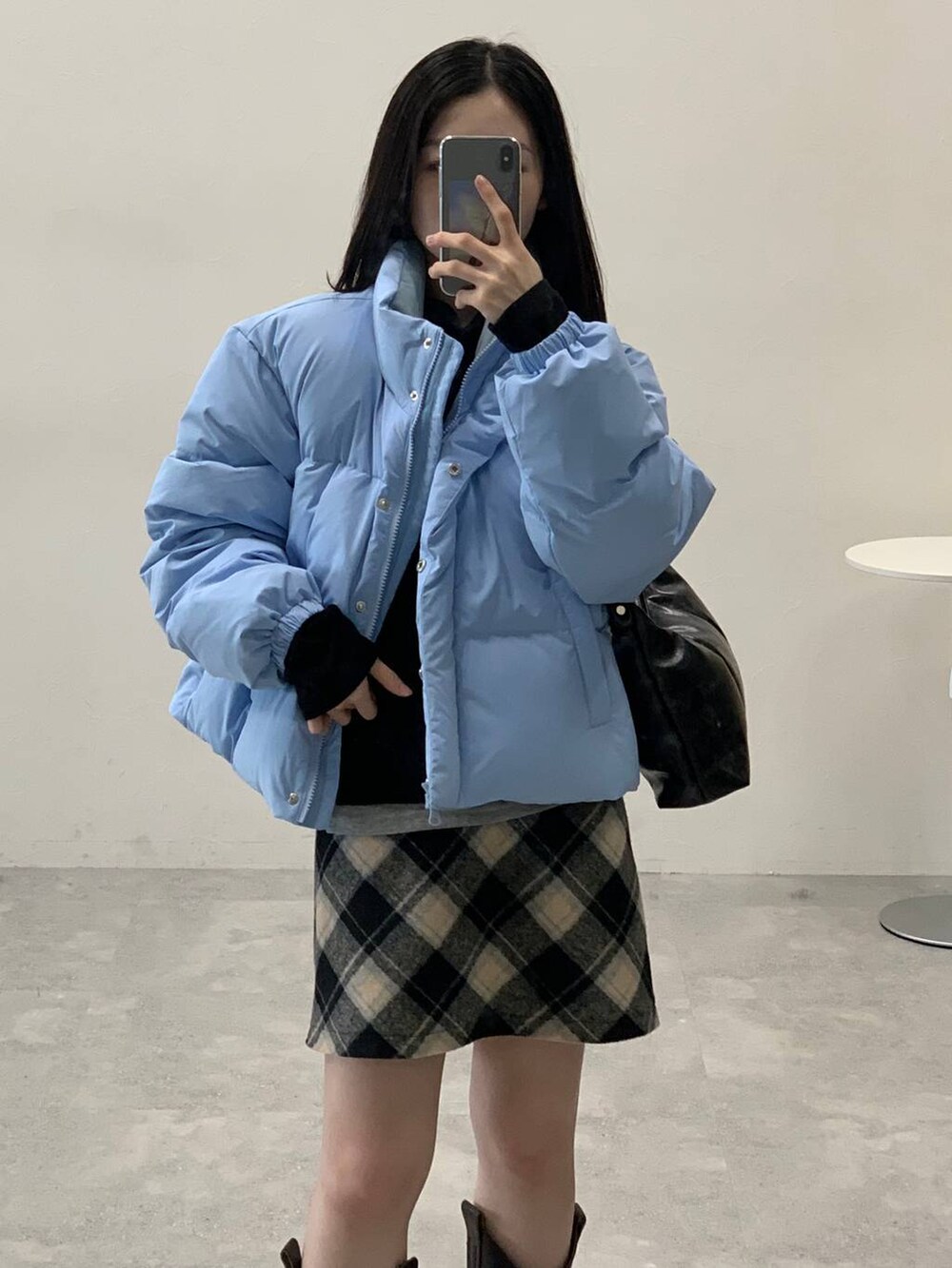 ブラック系のスカート、ブラック系のハンドバッグ、ブラック系のTシャツ/カットソーを着用したレディースの冬コーディネートの8枚目の写真