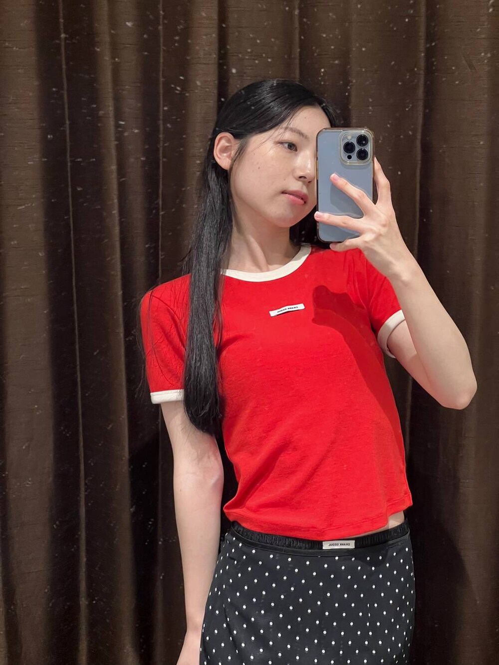 ブラック系のトートバッグ、ブラック系のスカート、レッド系のTシャツ/カットソーを着用したレディースの夏コーディネートの6枚目の写真