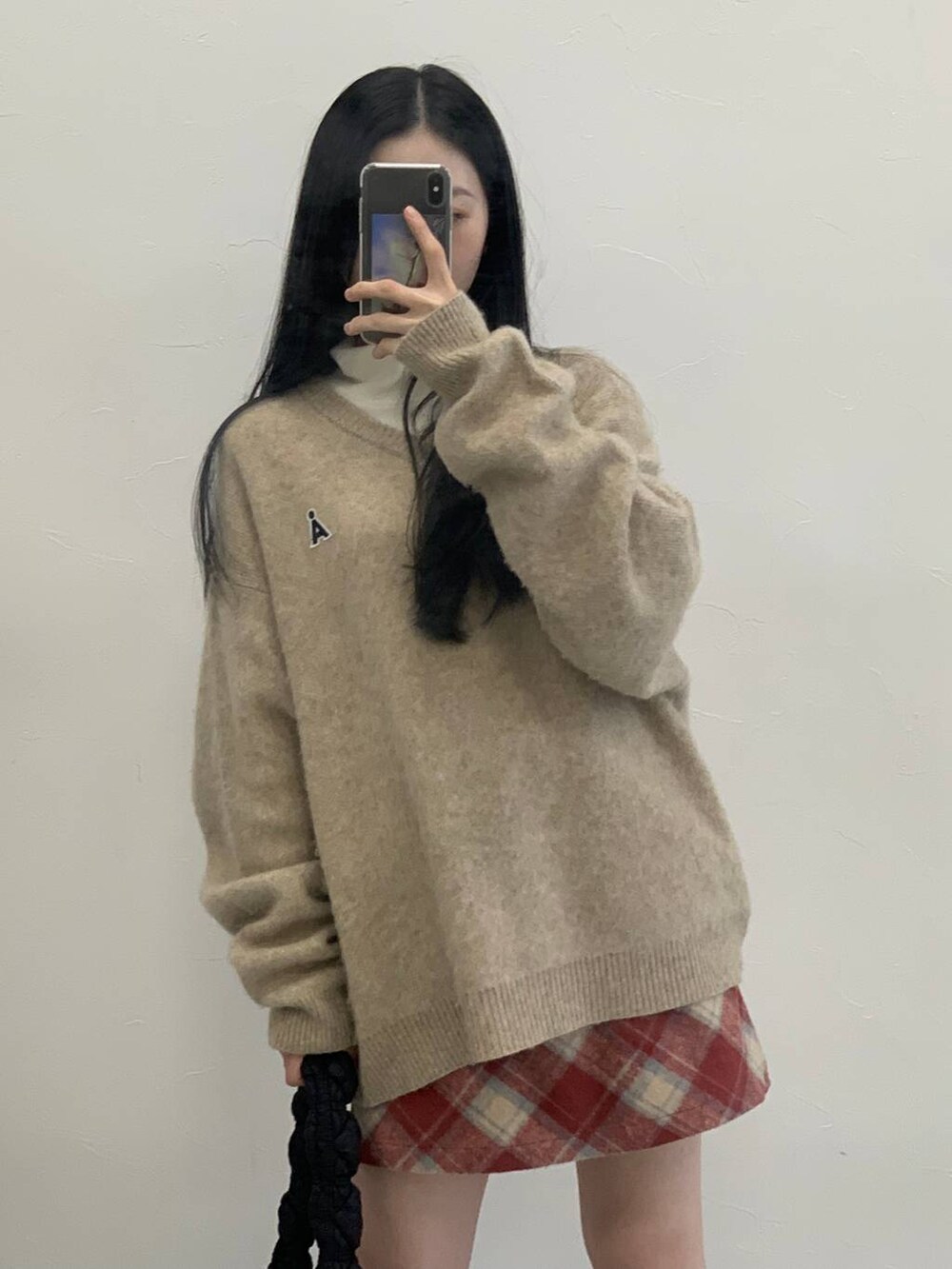 ブラック系のショルダーバッグ、レッド系のスカート、ベージュ系のTシャツ/カットソーを着用したレディースの冬コーディネートの6枚目の写真