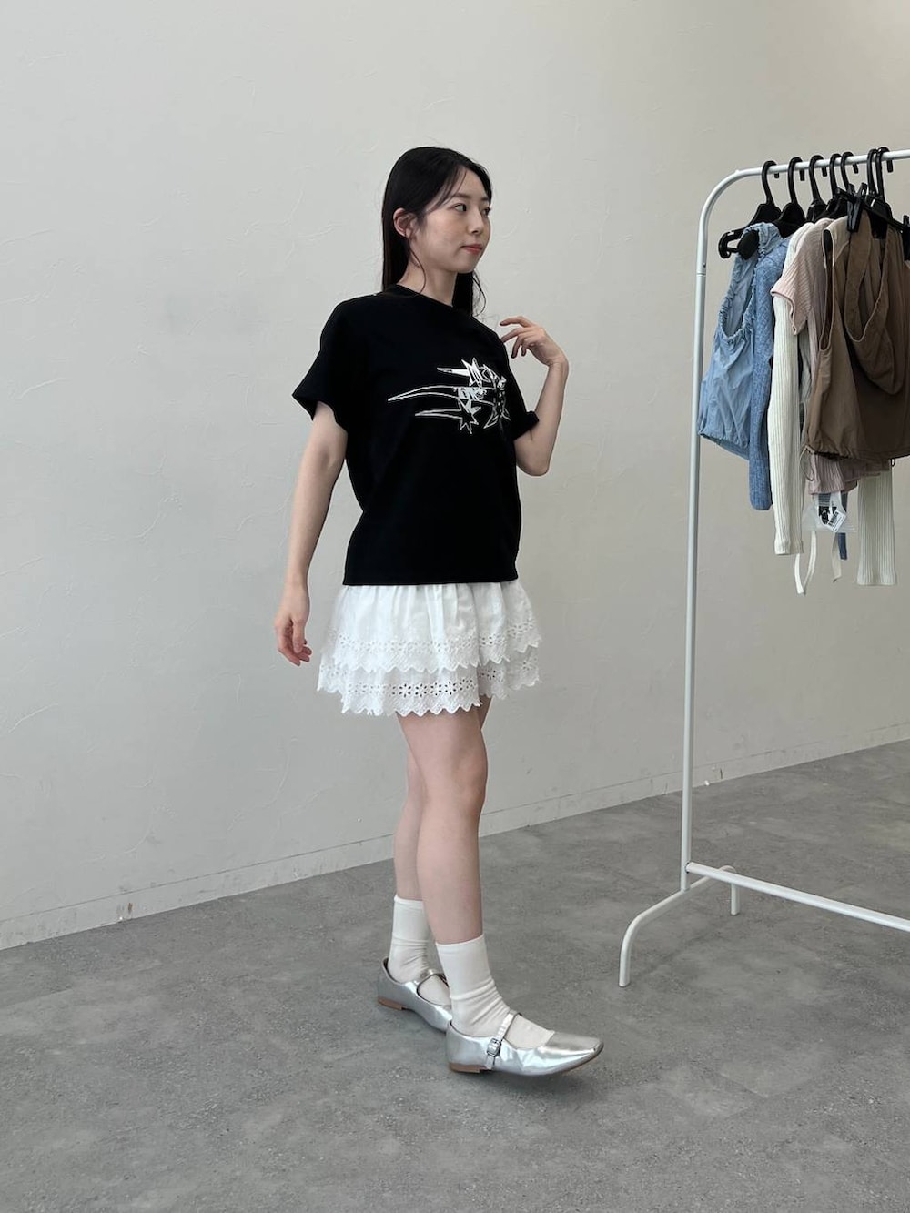 ホワイト系のスカート、ブラック系のTシャツ/カットソーを着用したレディースの夏コーディネートの2枚目の写真