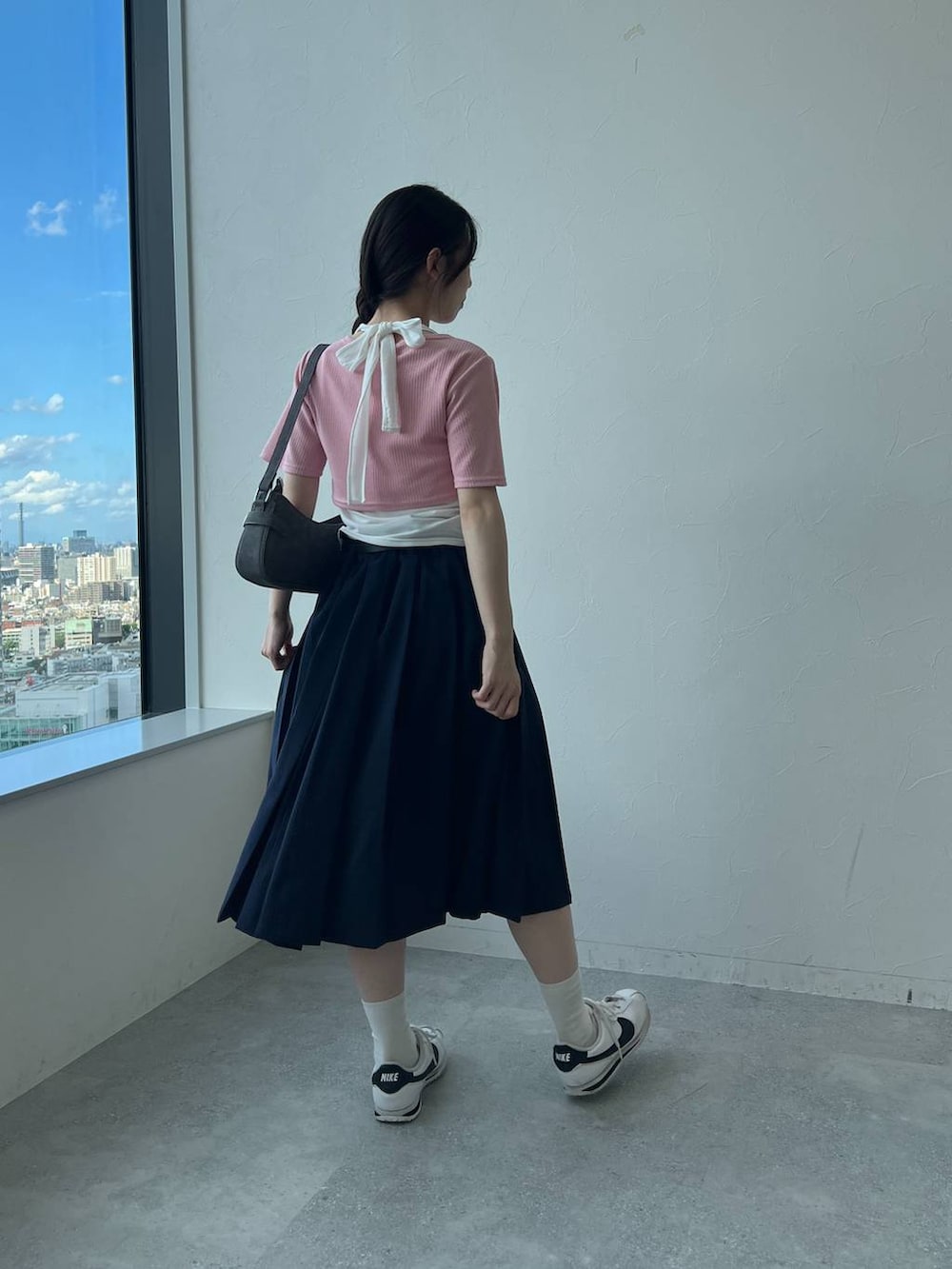 ブルー系のスカート、ブラック系のトートバッグ、ピンク系のカーディガン/ボレロを着用したレディースの夏コーディネートの5枚目の写真