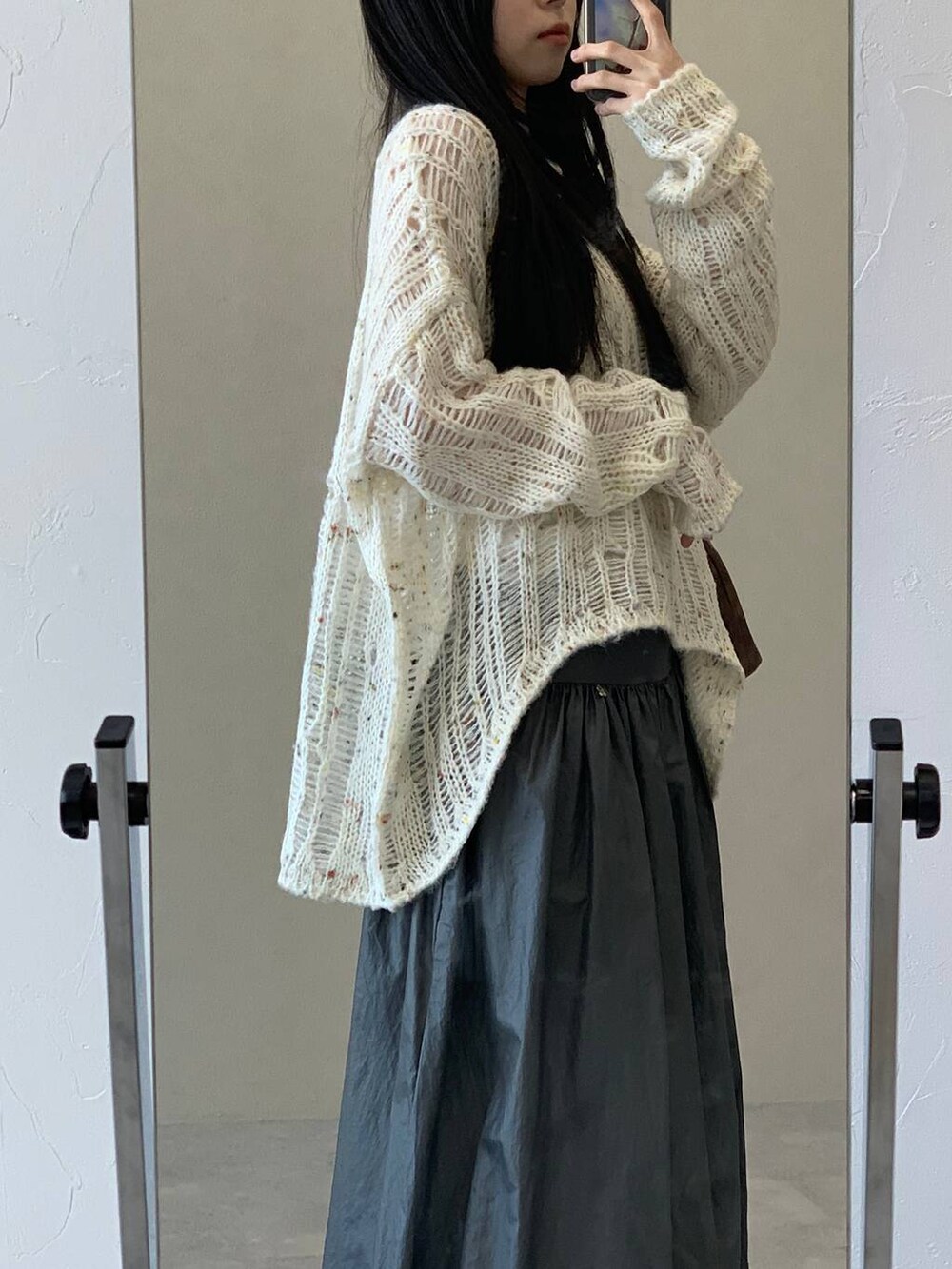 ブラウン系のハンドバッグ、ベージュ系のニット/セーター、グレー系のスカートを着用したレディースの冬コーディネートの7枚目の写真