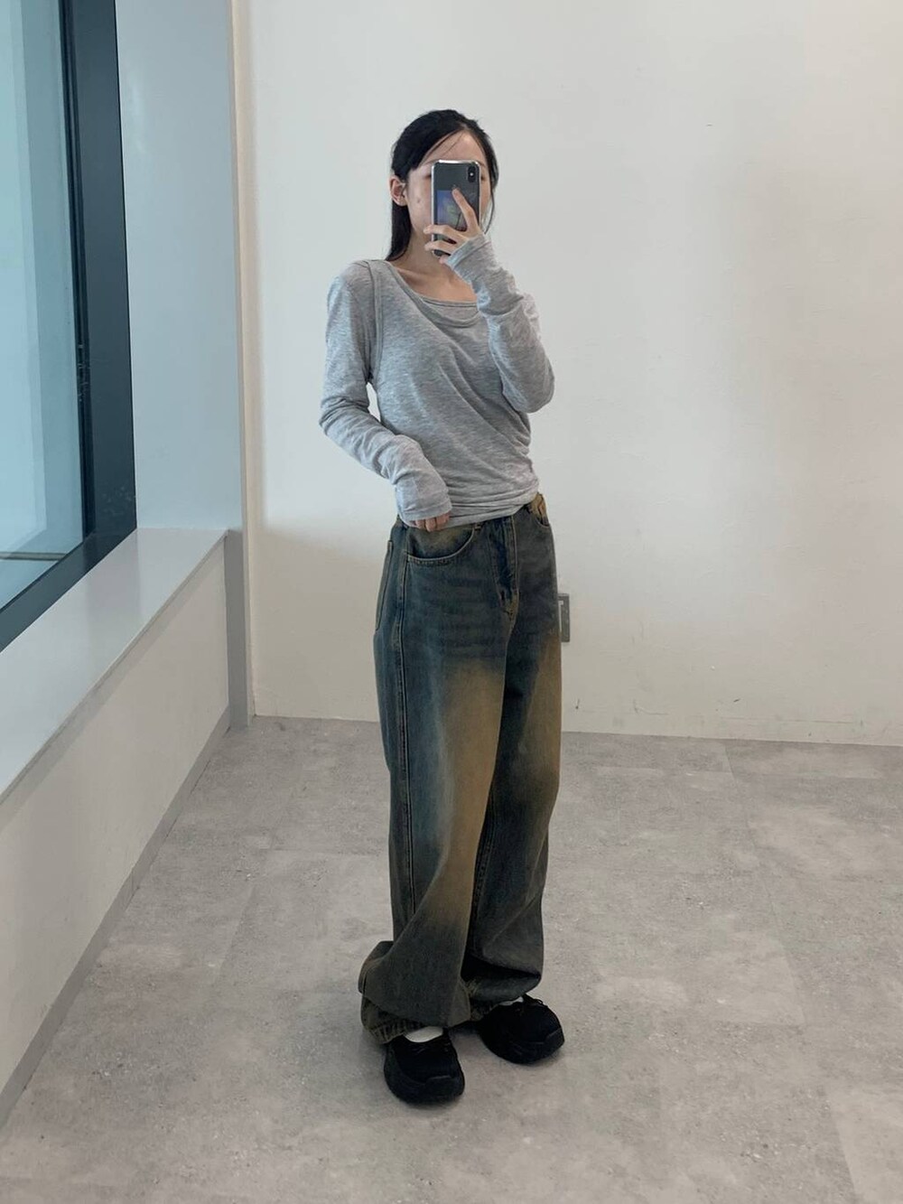 ブルー系のデニムパンツ、グレー系のTシャツ/カットソーを着用したレディースの秋コーディネートの5枚目の写真