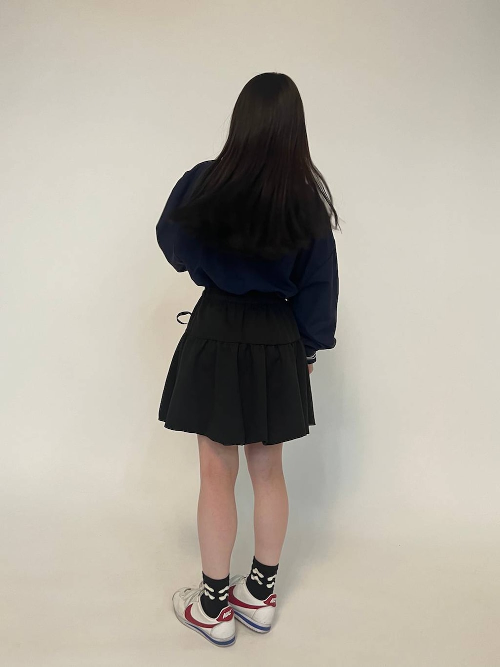 ブラック系のスウェット、ブラック系のスカートを着用したレディースの冬コーディネートの4枚目の写真