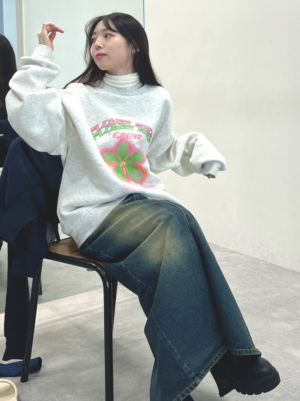 ブラック系のブーツ、ブルー系のデニムスカート、ベージュ系のTシャツ/カットソーを着用したレディースの冬コーディネートの4枚目の写真