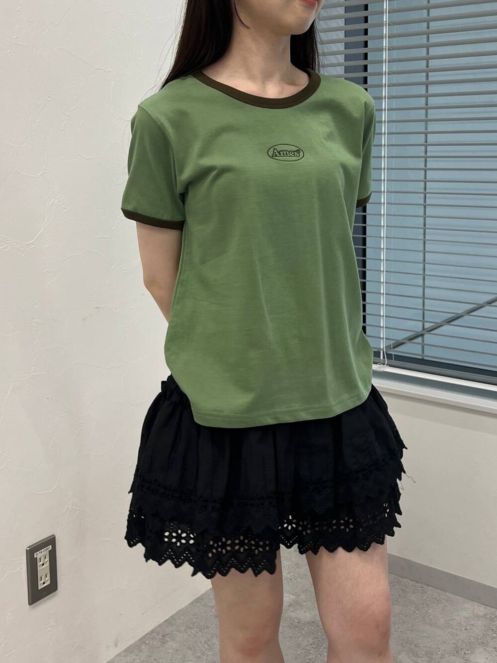 ブラック系のスカート、グリーン系のTシャツ/カットソーを着用したレディースの夏コーディネートの5枚目の写真