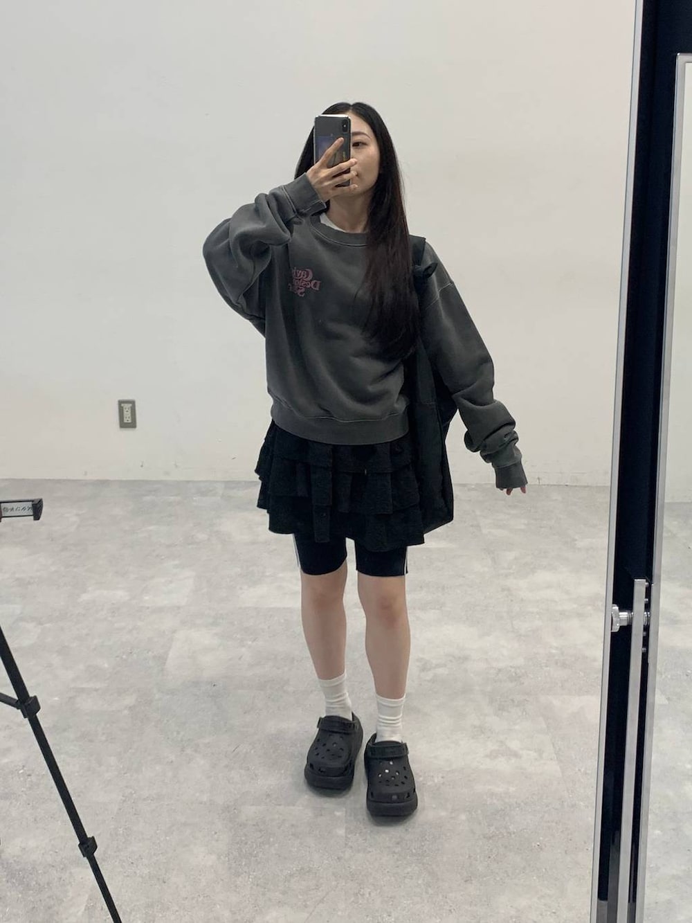 ブラック系のサンダル、ブラック系のショルダーバッグ、ブラック系のスカートを着用したレディースの秋コーディネートの2枚目の写真